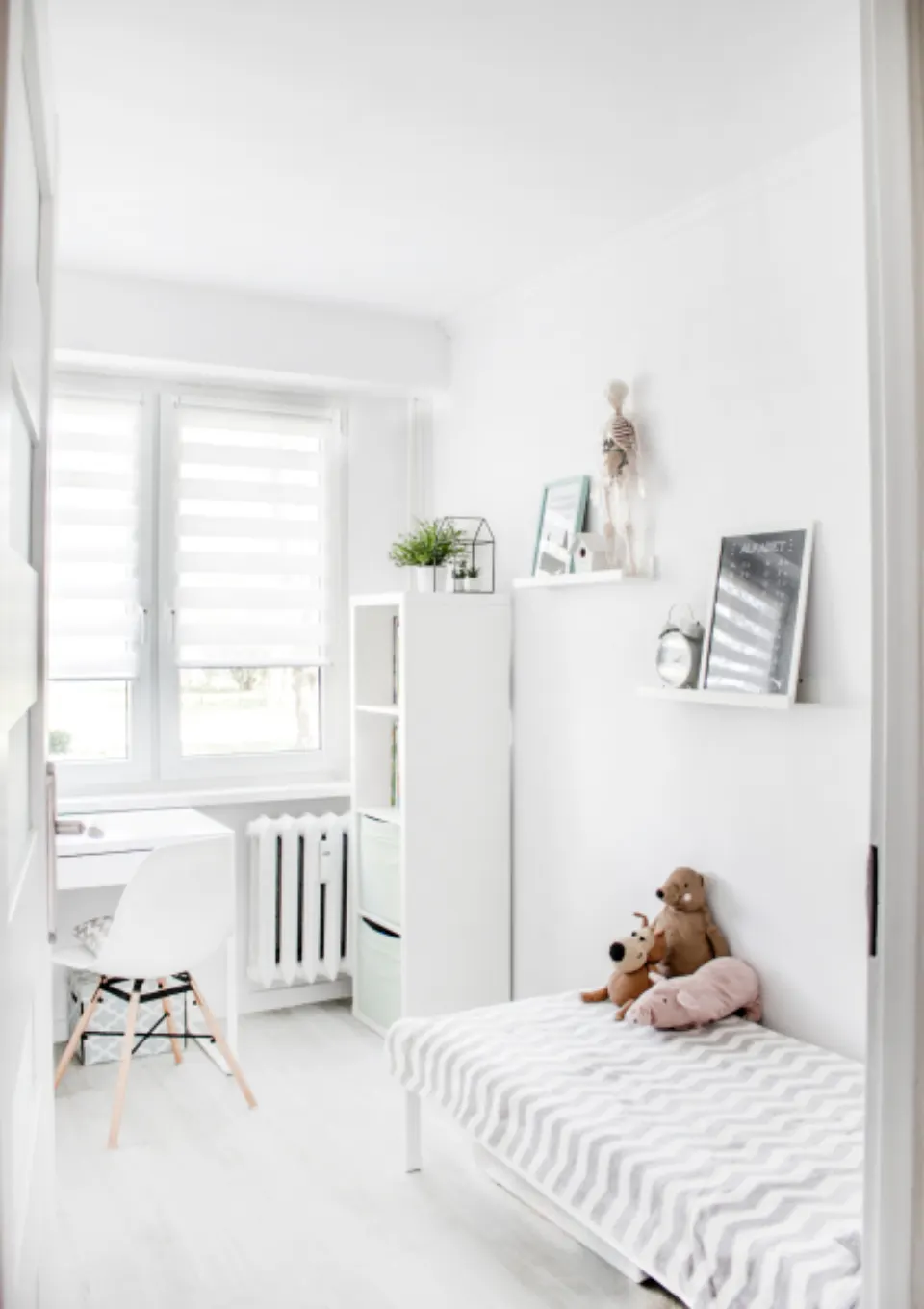 Small white bedroom with a radiator and simple decor